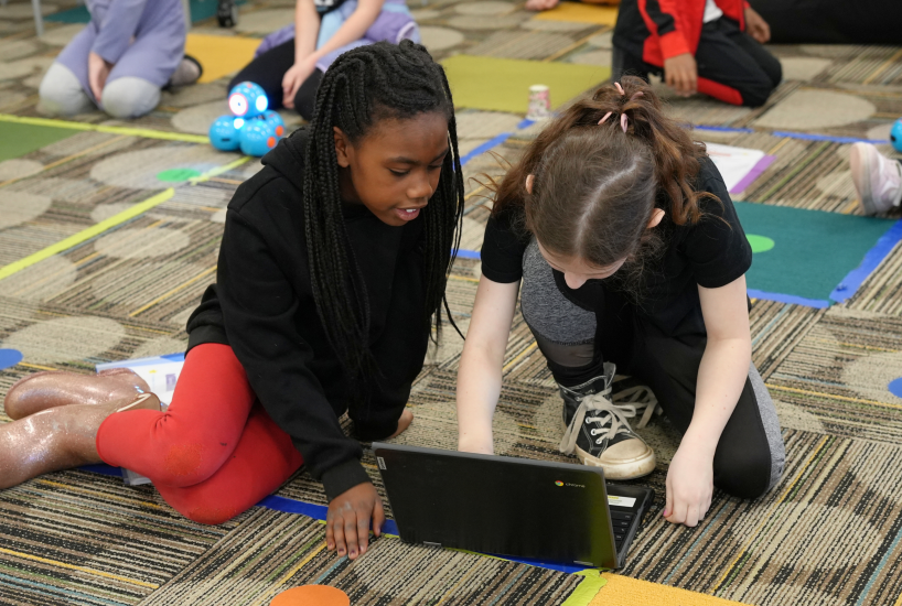 students work on a project together on a laptop